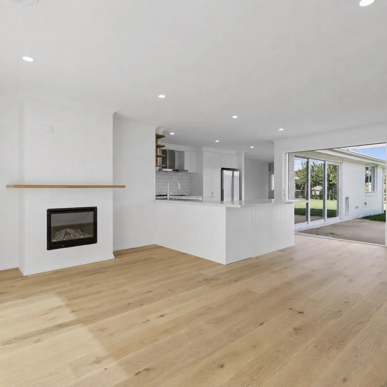 Curved rendered fireplace wall and travertine flooring